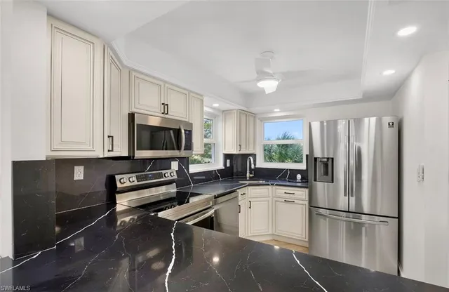 a kitchen with a refrigerator a sink and cabinets
