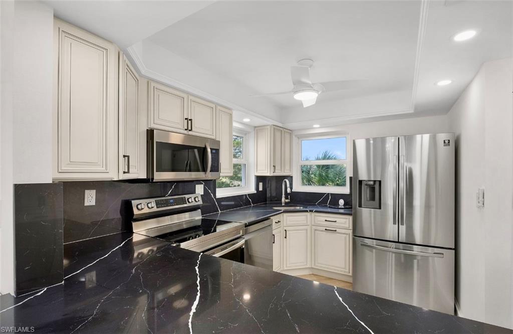 29 High Point Circle East, Unit 308 Naples, FL 34103 - Photo 11 of 39 a kitchen with a refrigerator a sink and cabinets