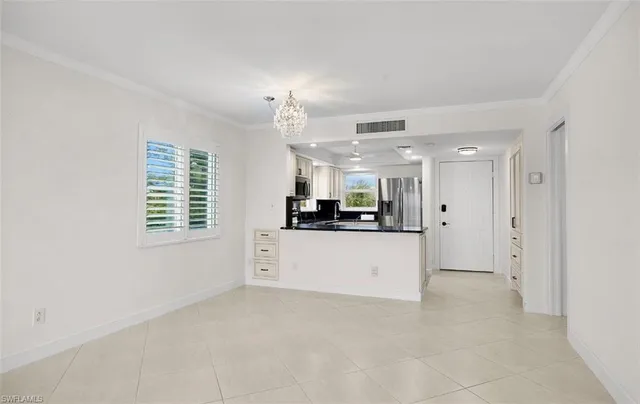 a view of kitchen with stainless steel appliances cabinets and a window