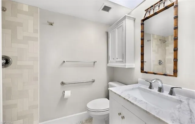 a bathroom with a granite countertop toilet sink and a mirror