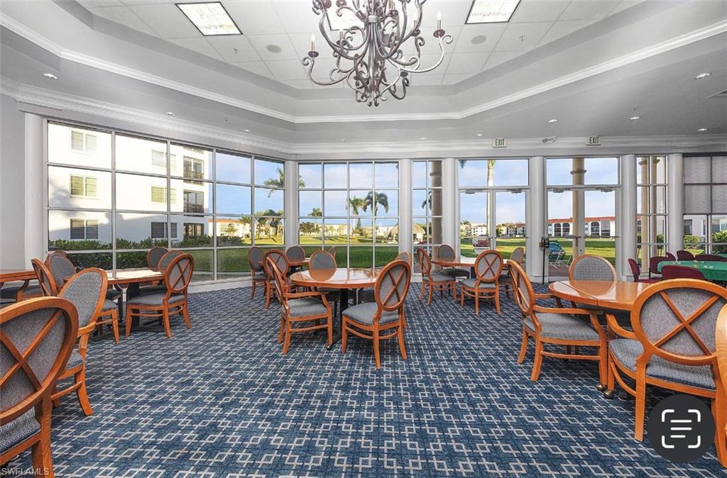 29 High Point Circle East, Unit 308 Naples, FL 34103 - Photo 37 of 39 a room with lots of tables a large window and chairs