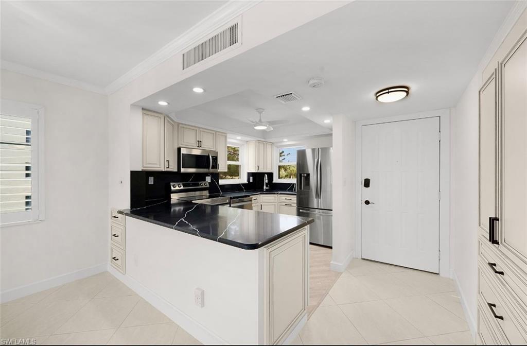 29 High Point Circle East, Unit 308 Naples, FL 34103 - Photo 9 of 39 a kitchen with stainless steel appliances granite countertop a sink a refrigerator and a granite counter tops