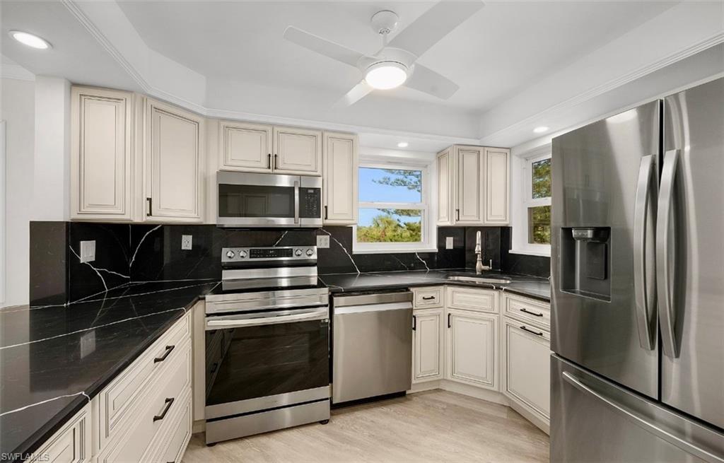 29 High Point Circle East, Unit 308 Naples, FL 34103 - Photo 10 of 39 a kitchen with a sink stove and microwave