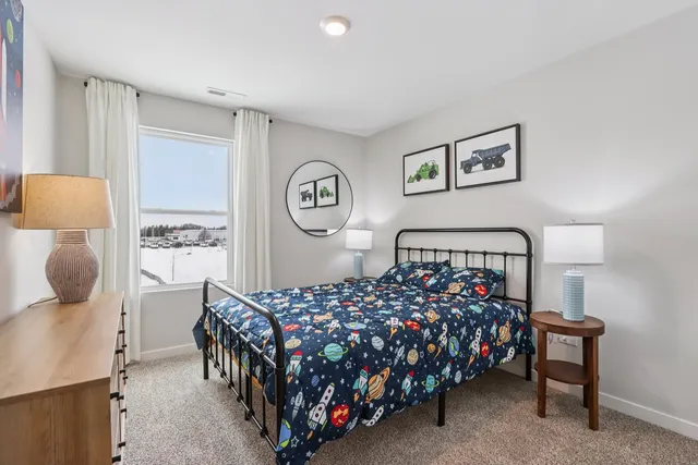 a bedroom with a bed and painting on the wall