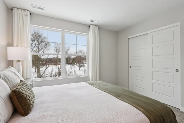 a bedroom with a large bed and a large window