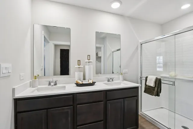 a bathroom with double vanity sinks and a mirror