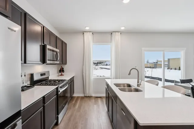 a kitchen with stainless steel appliances a sink a stove and cabinets