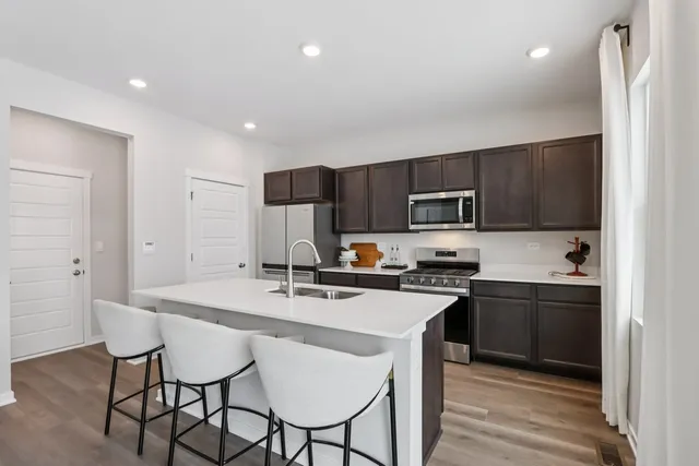 a kitchen with stainless steel appliances wooden cabinets a stove a sink and a refrigerator