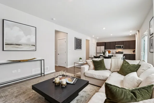 a living room with furniture and view of kitchen