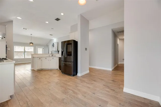 a view of kitchen with refrigerator and wooden floor