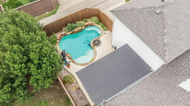 an aerial view of a house a yard and a wooden fence