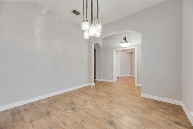 a view of an empty room with a chandelier fan