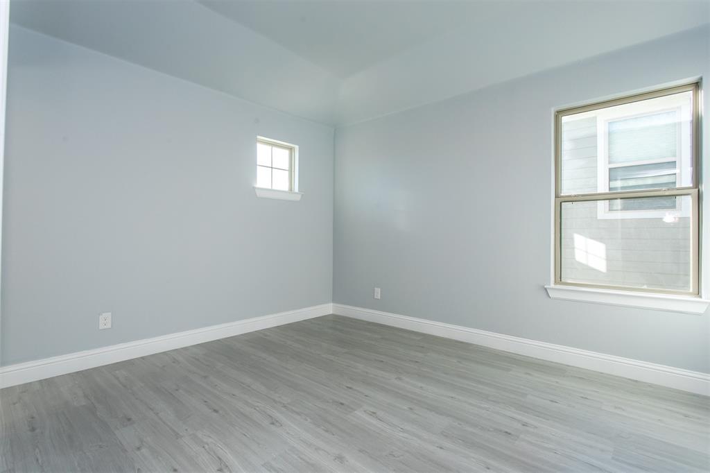 415 West Elm Street, Unit 415 Denison, TX 75020 - Photo 11 of 17 an empty room with wooden floor and windows