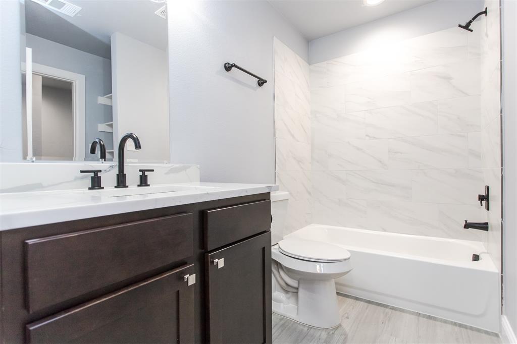 415 West Elm Street, Unit 415 Denison, TX 75020 - Photo 13 of 17 a bathroom with a sink a toilet and a bathtub