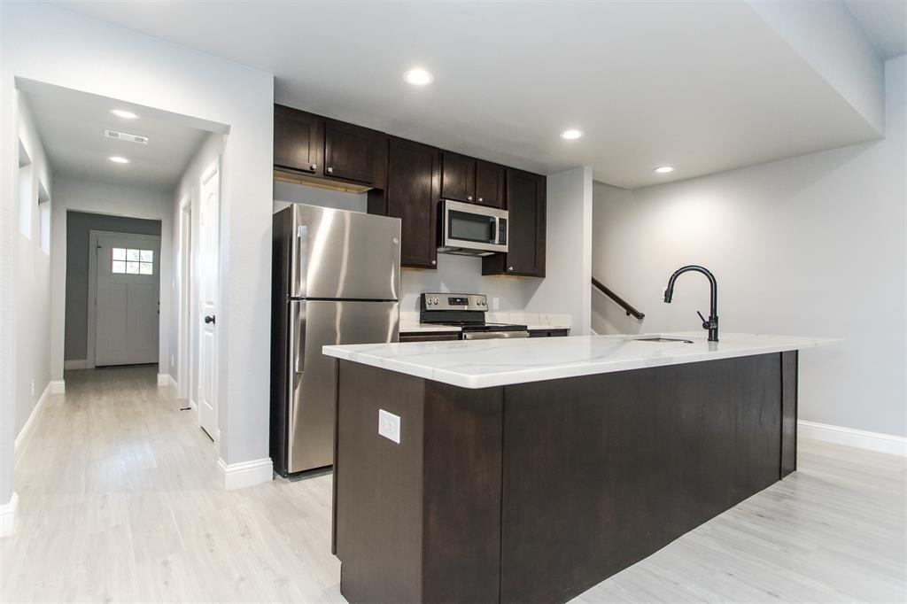 415 West Elm Street, Unit 415 Denison, TX 75020 - Photo 4 of 17 a kitchen with stainless steel appliances granite countertop a sink and a refrigerator