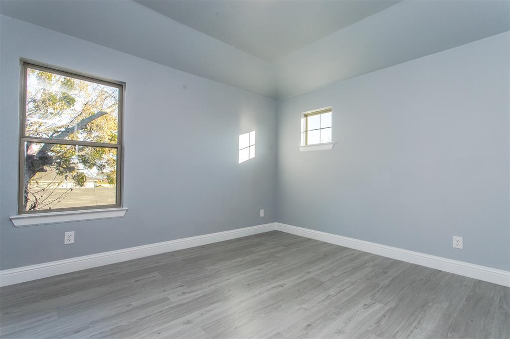 415 West Elm Street, Unit 415 Denison, TX 75020 - Photo 7 of 17 a view of an empty room with wooden floor and a window