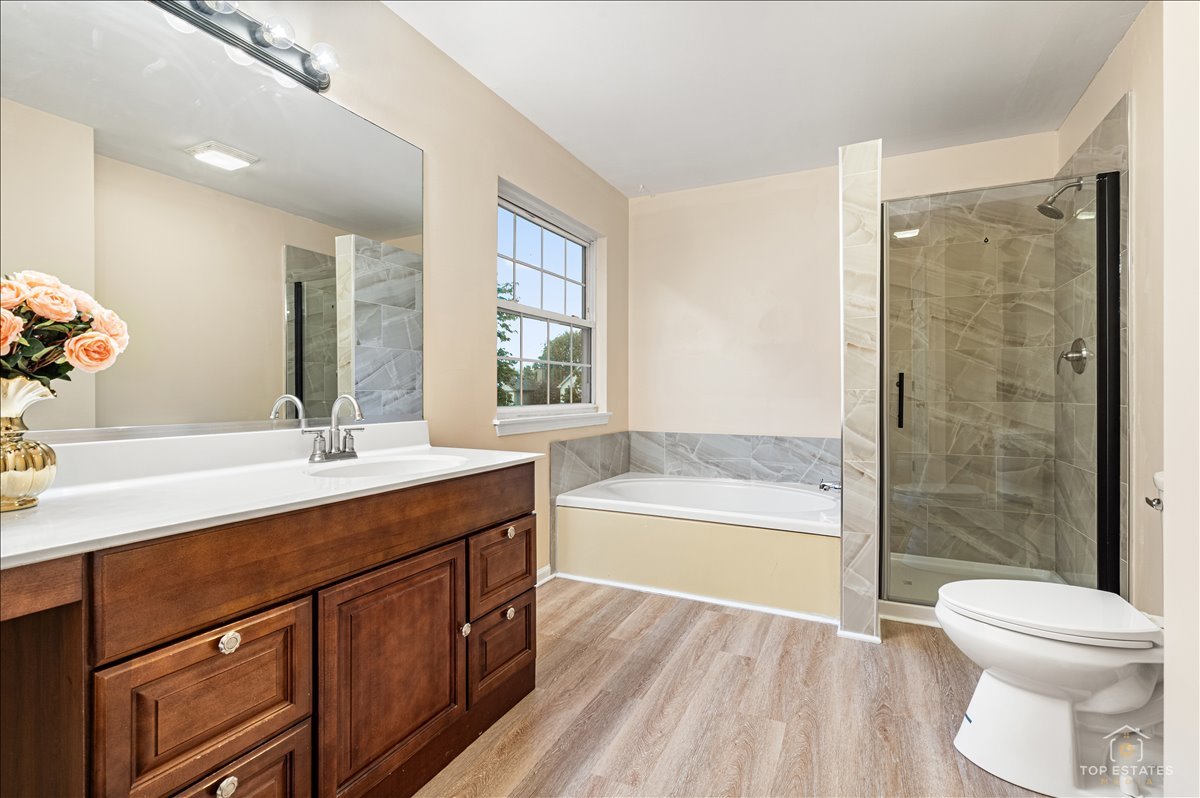 7 Eagle Court Streamwood, IL 60107 - Photo 22 of 31 a bathroom with a granite countertop sink toilet a large mirror a bathtub and shower