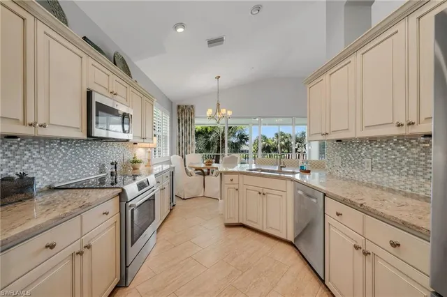 a kitchen with stainless steel appliances granite countertop white cabinets granite counter tops and a hard wood floors