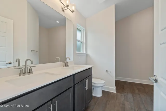 a bathroom with a sink a toilet and a large mirror
