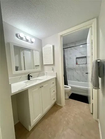 a bathroom with a double vanity sink a toilet a mirror and shower