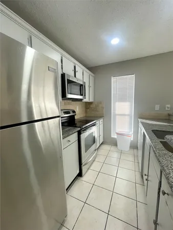 a kitchen with granite countertop a refrigerator and a sink