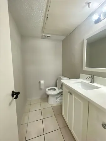 a bathroom with a toilet sink and a mirror