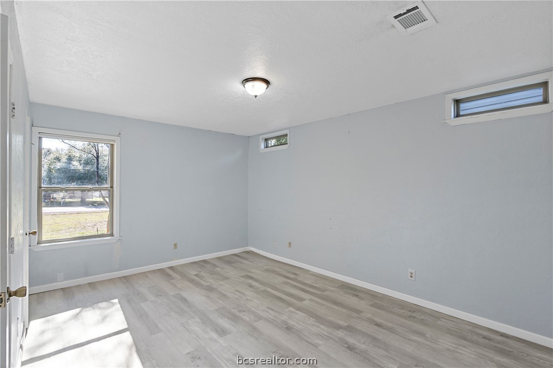 8801 Old Reliance Road Bryan, TX 77808 - Photo 15 of 24 Spacious primary bedroom with neutral flooring and multiple windows for natural light.