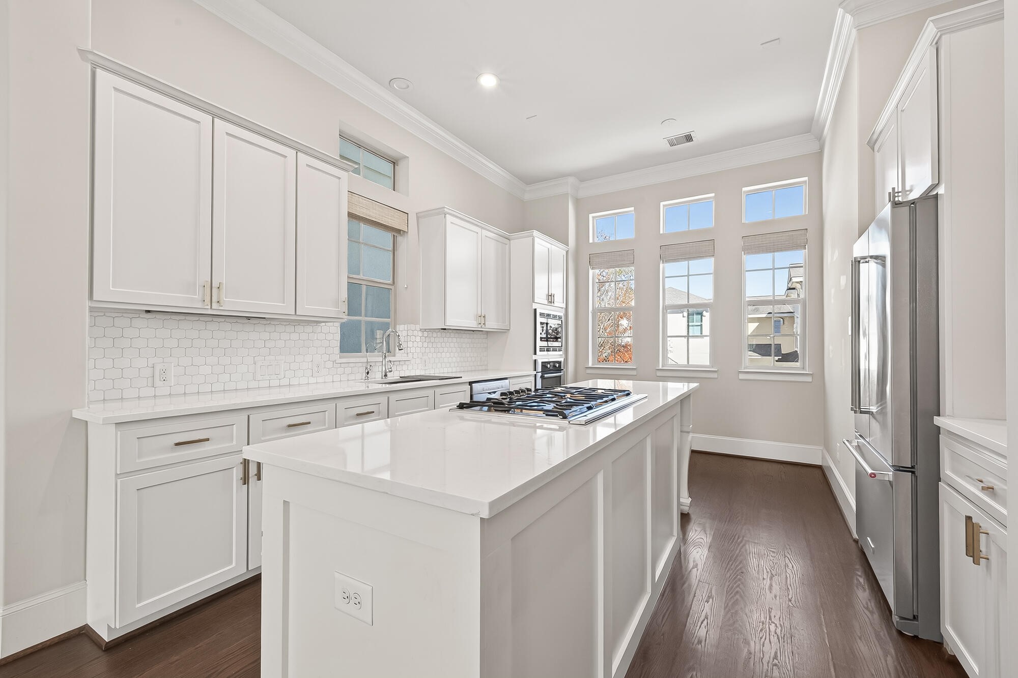 122 Gateway Park Place Spring, TX 77380 - Photo 20 of 44 Remodeled kitchen shines with quartz island, gas cooktop, crisp cabinetry, and plantation shutters.