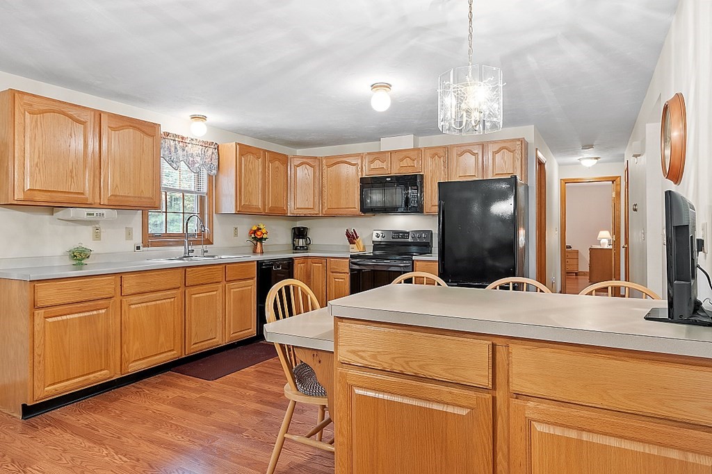 252 Great Road Shirley, MA 01464 - Photo 18 of 42 a kitchen with kitchen island a stove a sink a refrigerator and cabinets