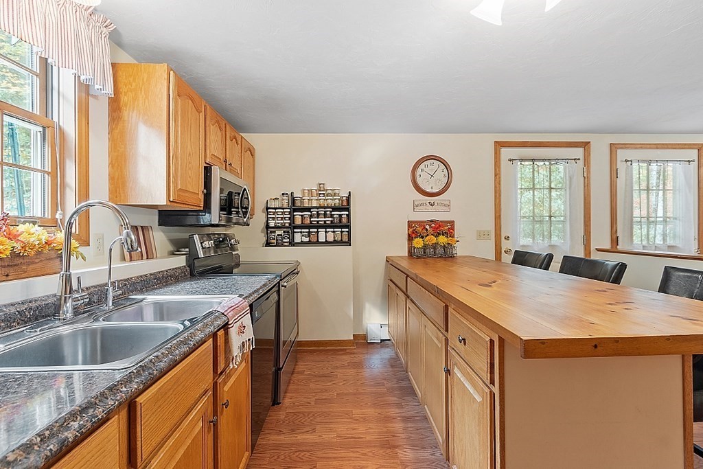 252 Great Road Shirley, MA 01464 - Photo 29 of 42 a kitchen with stainless steel appliances granite countertop a sink a stove and a refrigerator