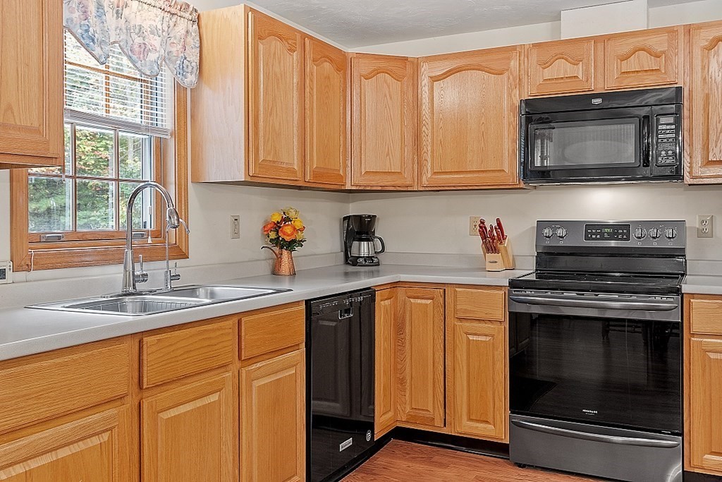 252 Great Road Shirley, MA 01464 - Photo 6 of 42 a kitchen with granite countertop stainless steel appliances a stove a sink and a microwave