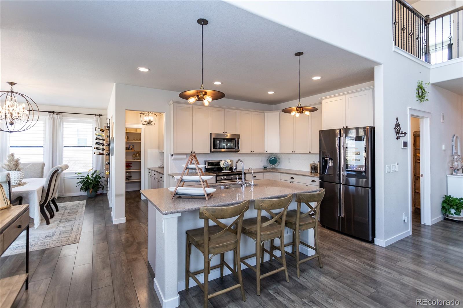 4208 Notch Trail Colorado Springs, CO 80924 - Photo 16 of 40 a kitchen with stainless steel appliances kitchen island granite countertop a dining table chairs stove and white cabinets
