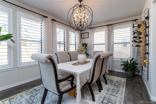 an empty room with wooden floor cabinet and windows