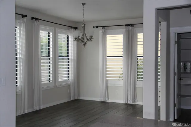 a bed sitting in a bedroom next to a window and a chandelier