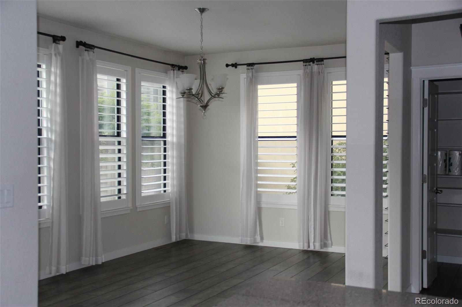 4208 Notch Trail Colorado Springs, CO 80924 - Photo 22 of 40 an empty room with wooden floor cabinet and windows