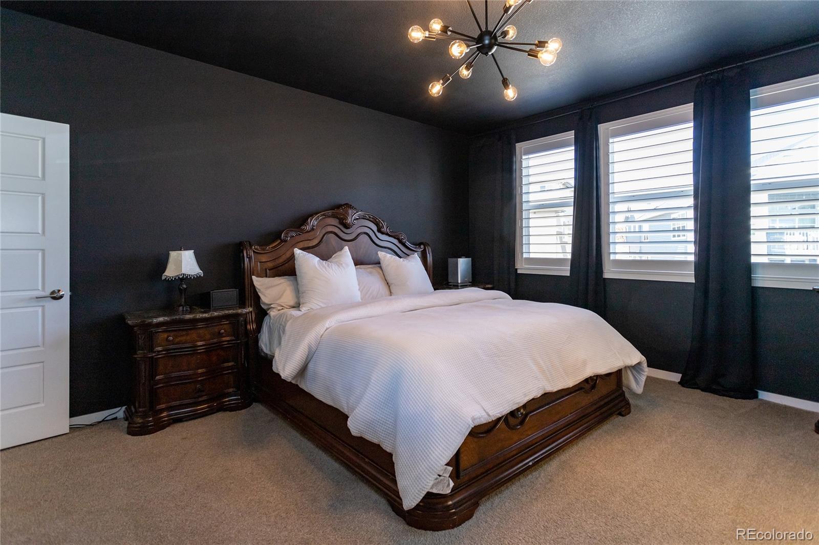 4208 Notch Trail Colorado Springs, CO 80924 - Photo 23 of 40 a bed sitting in a bedroom next to a window and a chandelier