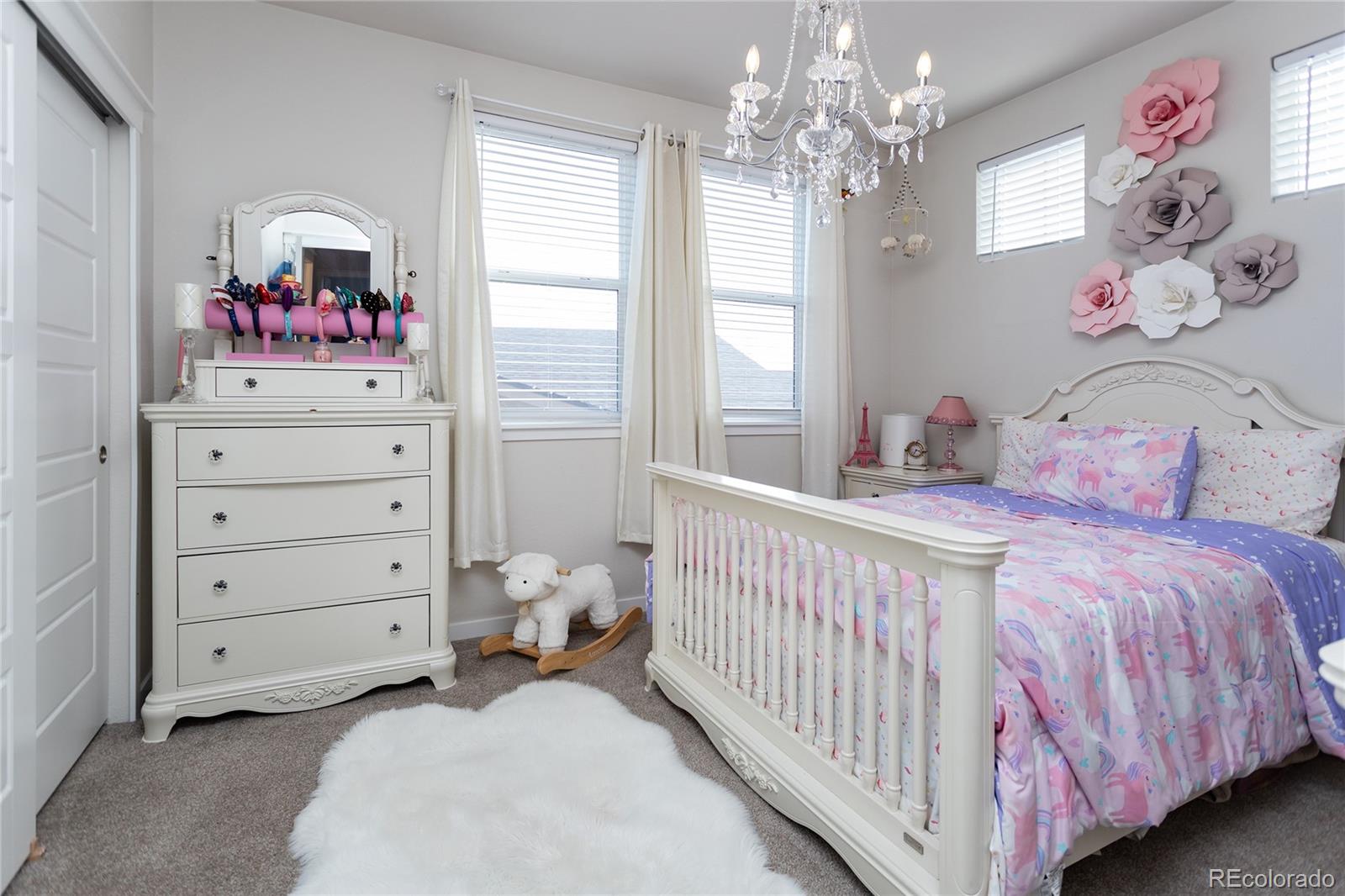 4208 Notch Trail Colorado Springs, CO 80924 - Photo 32 of 40 a bedroom with a bed and a chandelier