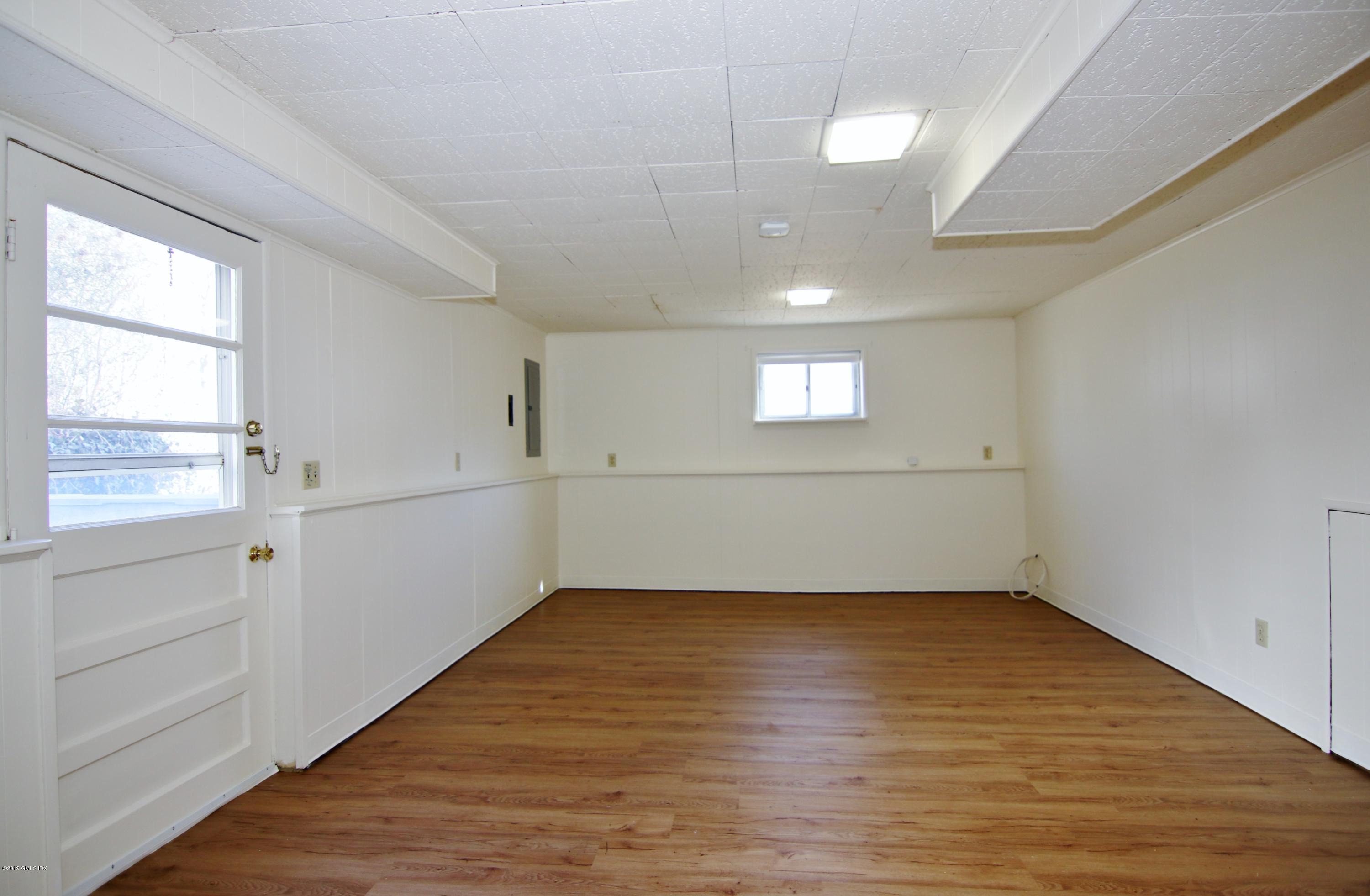 Undisclosed Address Riverside, CT 06878 - Photo 12 of 28 an empty room with wooden floor and windows