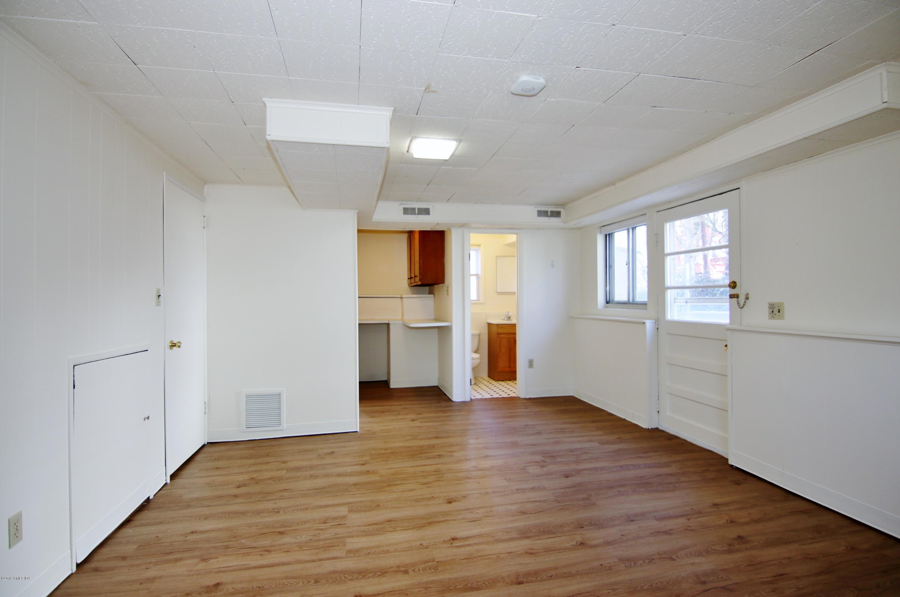 Undisclosed Address Riverside, CT 06878 - Photo 13 of 28 an empty room with wooden floor and windows