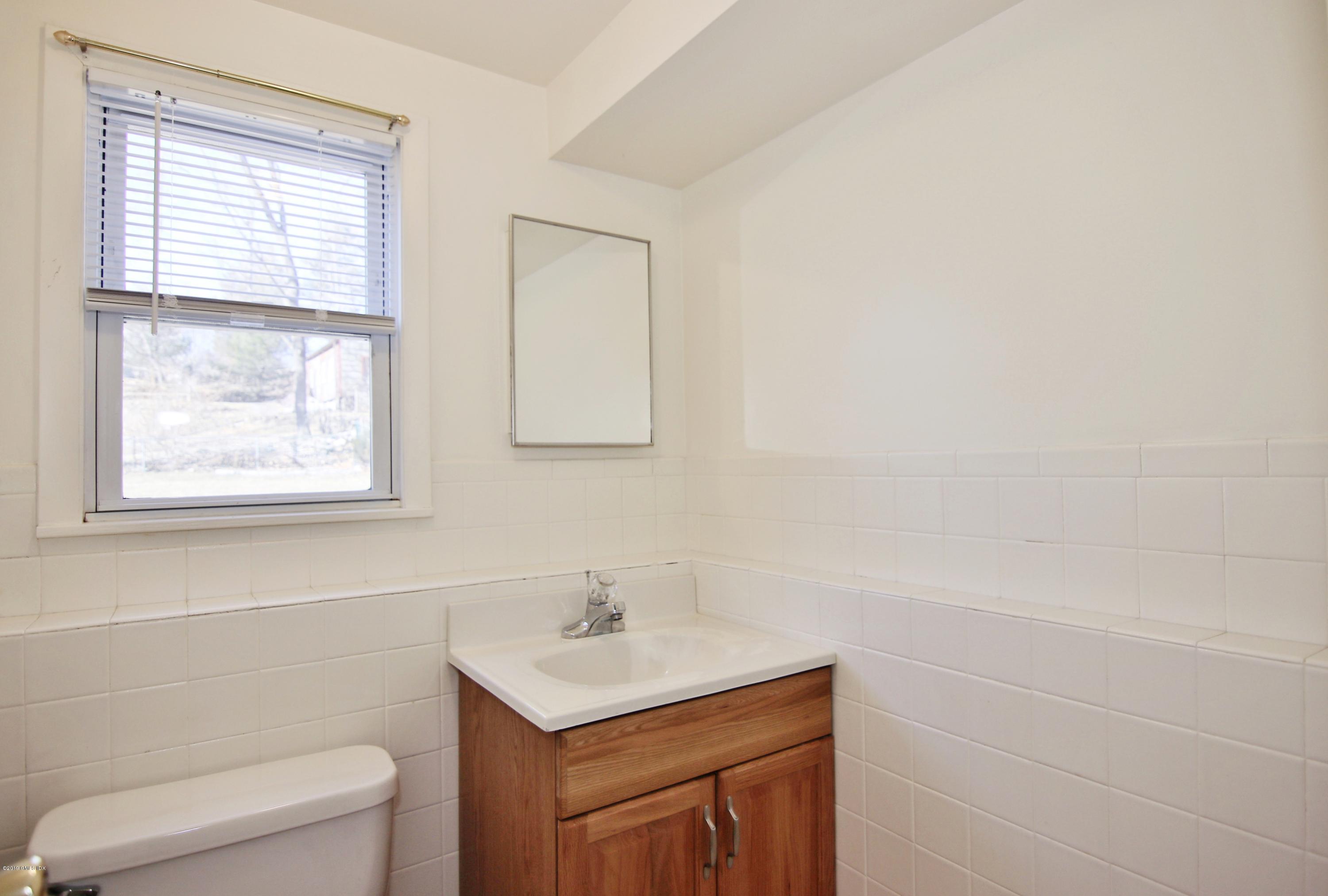 Undisclosed Address Riverside, CT 06878 - Photo 14 of 28 a bathroom with a toilet a sink a mirror and a window