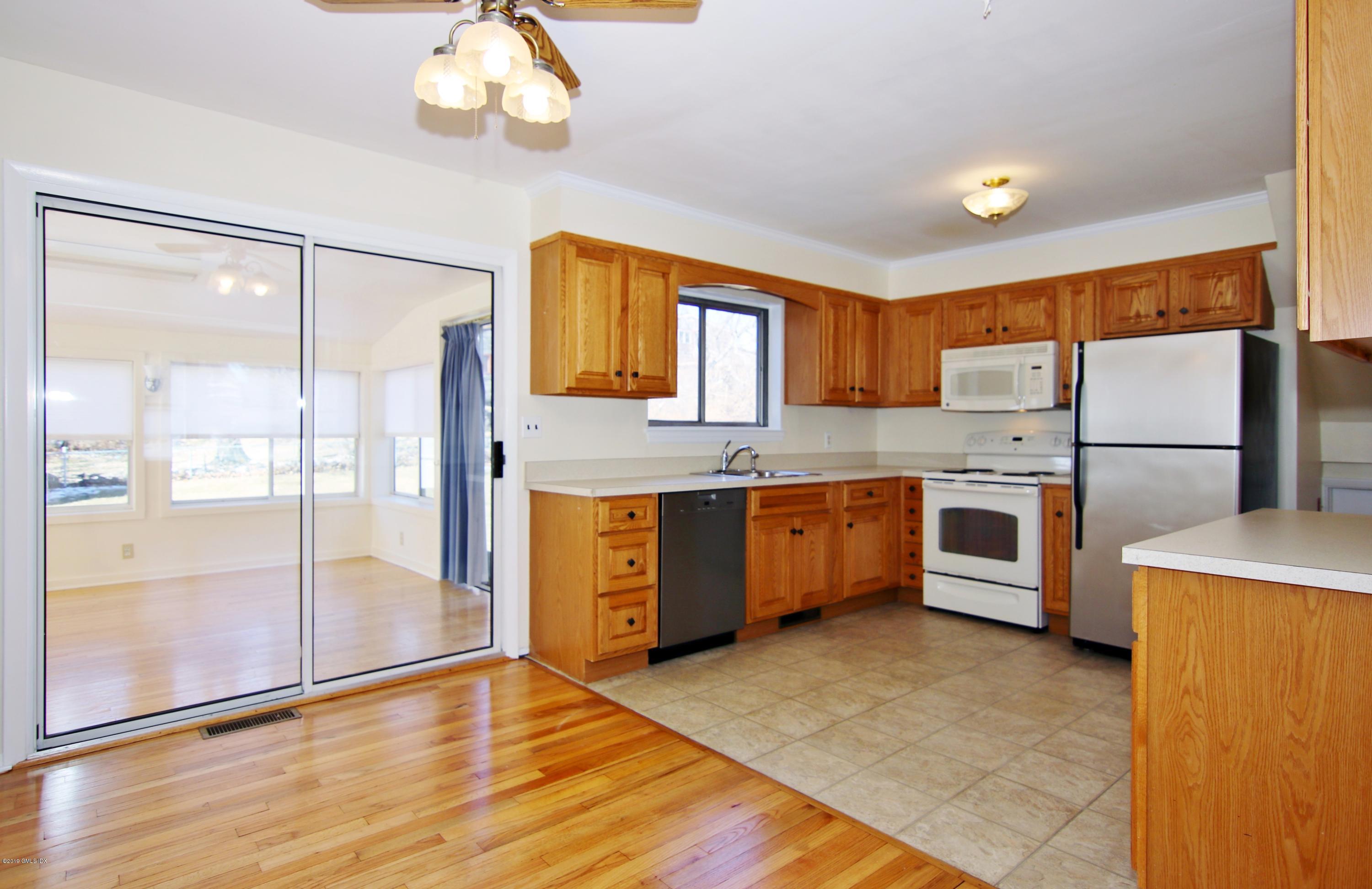 Undisclosed Address Riverside, CT 06878 - Photo 7 of 28 a kitchen with stainless steel appliances a stove a sink and a refrigerator