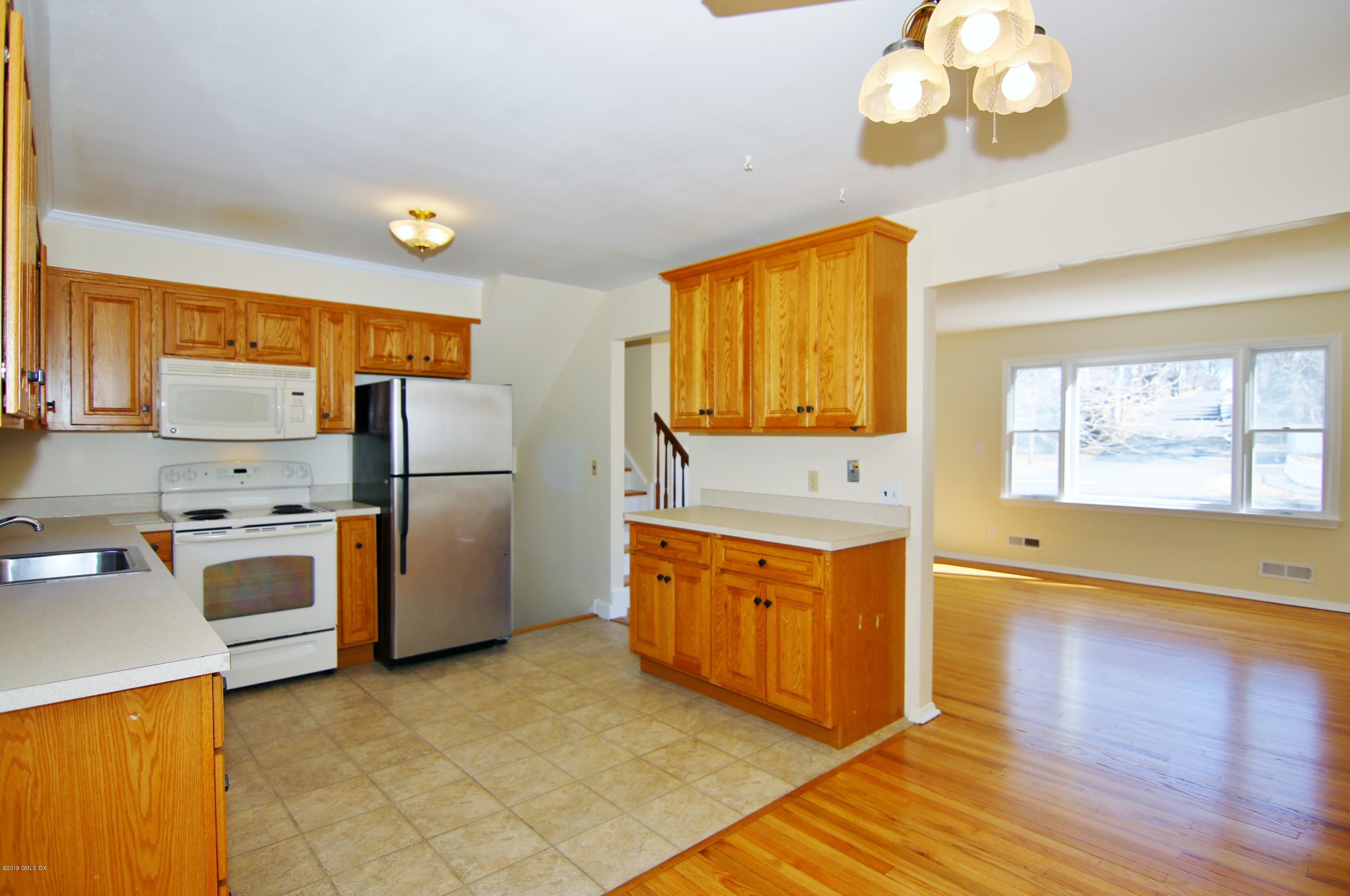 Undisclosed Address Riverside, CT 06878 - Photo 9 of 28 a kitchen with stainless steel appliances granite countertop a refrigerator a stove top oven a sink and dishwasher