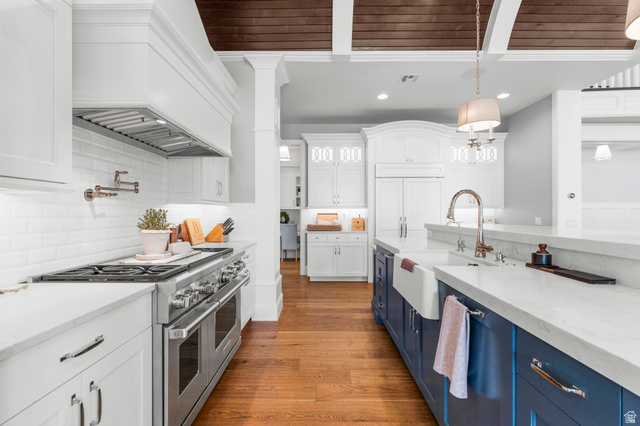 2917 Old Farm Road Washington, UT 84780 - Photo 20 of 105 Kitchen with stainless steel appliances, light stone counters, dual tone cabinetry, light wood-style floors, and pendant lighting
