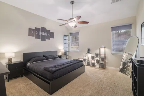 a spacious bedroom with a bed a furniture and a chandelier