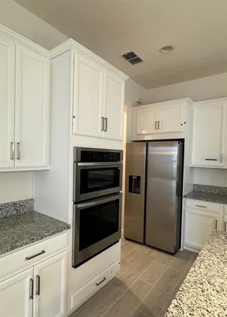 a kitchen with white cabinets and stainless steel appliances