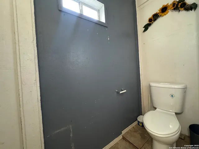 a white toilet sitting next to a white sink and vanity