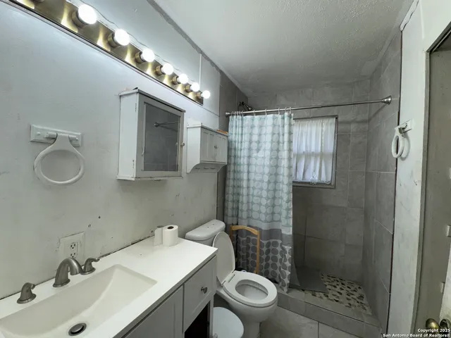 a bathroom with a sink toilet and shower