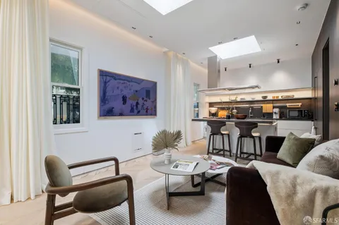 a living room with furniture kitchen view and a large window