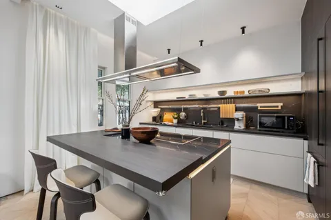 a kitchen with a sink a stove and chairs