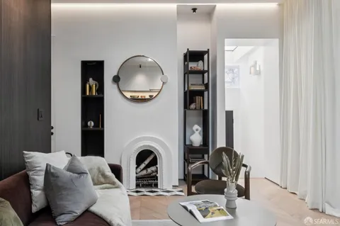 a living room with furniture a mirror and a fireplace